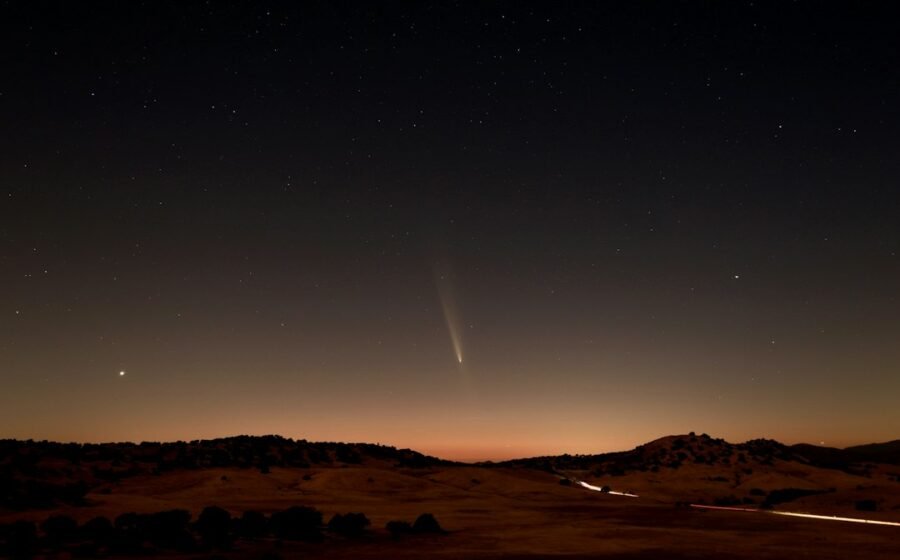 Photograph of comet C/2023 A3 Tsuchinshan–ATLAS in Earth's night sky; illustrative of comet impacts, not an image of the early Earth