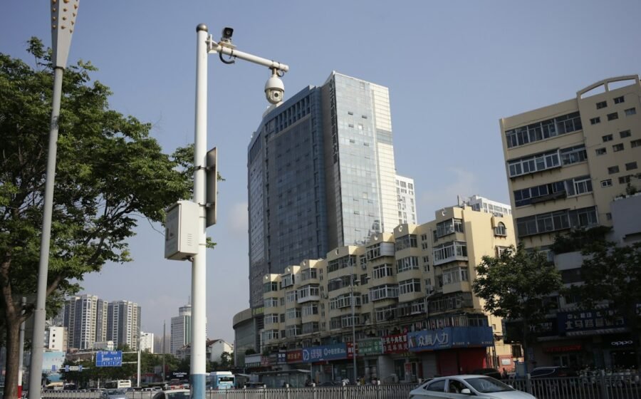 A surveillance camera on a tall pole overlooking a busy city street; illustrative image, not a Flock Safety device shown in the film