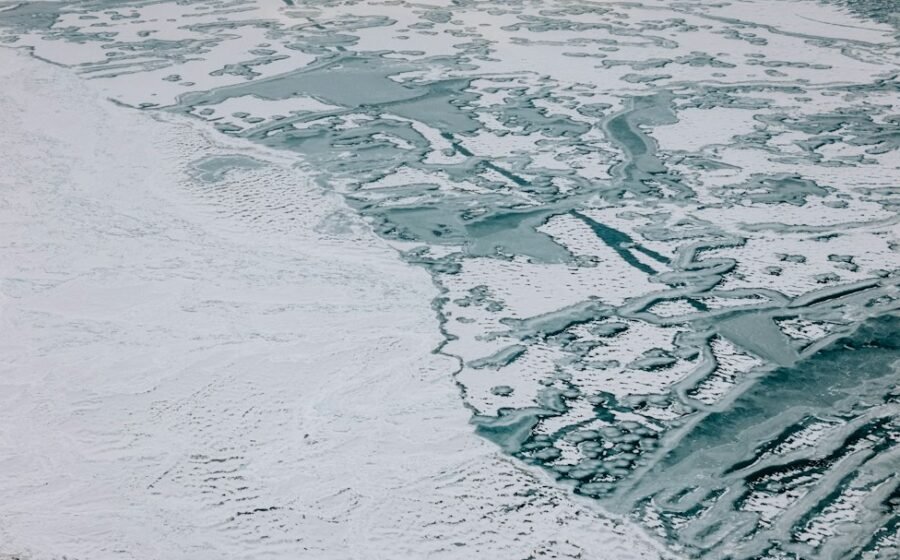 Aerial photograph of sea ice covering ocean water on Earth, illustrating proposed chemical environments on ocean worlds