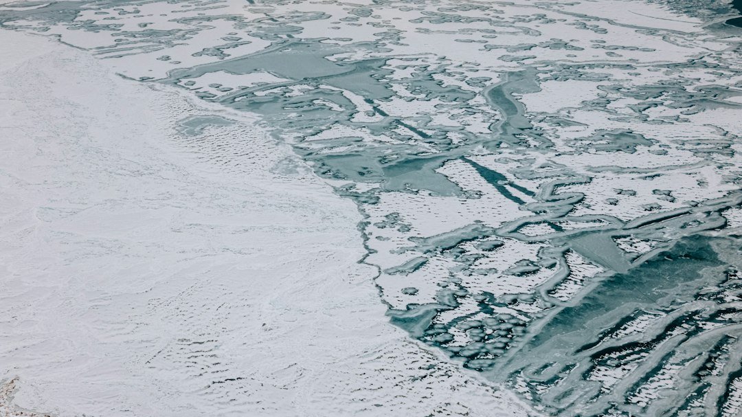 Aerial photograph of sea ice covering ocean water on Earth, illustrating proposed chemical environments on ocean worlds