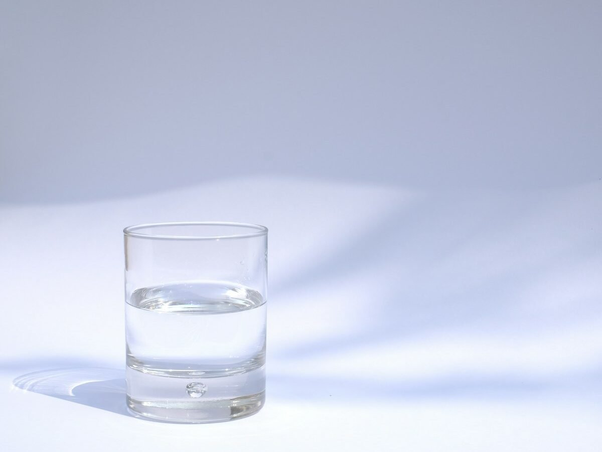 An ordinary glass of clear water illuminated by natural light, illustrating research on so-called structured water; the image does not depict evidence of molecular structuring or a water-treatment experiment