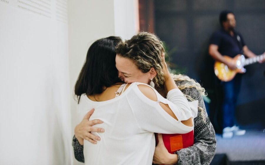 Two people share a warm, supportive hug, illustrating the emotional memories of touch.