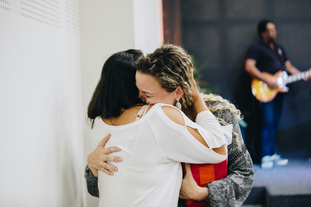 Two people share a warm, supportive hug, illustrating the emotional memories of touch.