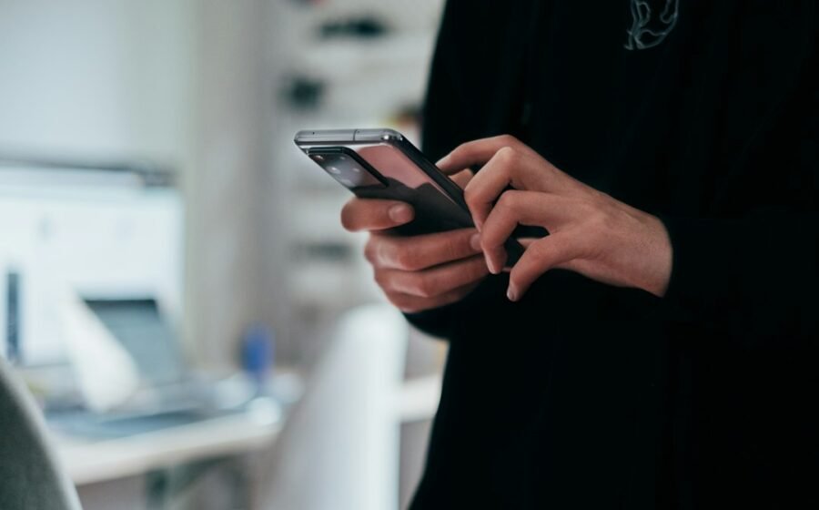 Smartphone held in a hand, illustrating digital surveillance through online advertising